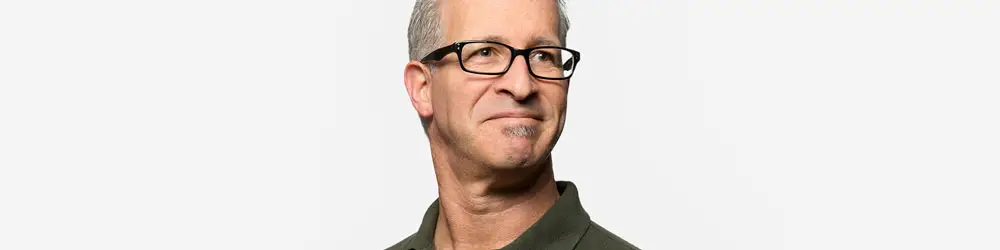 LEE_Image_Homme Smiling middle-aged man in glasses and green shirt, ideal for GuestLee luxury rentals in Geneva, Zermatt, and Swiss destinations. | GuestLee luxury rental Switzerland