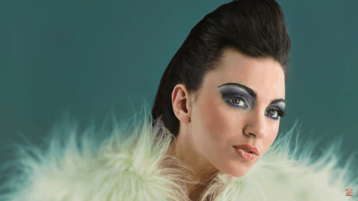 model in front of teal background wearing furry boa