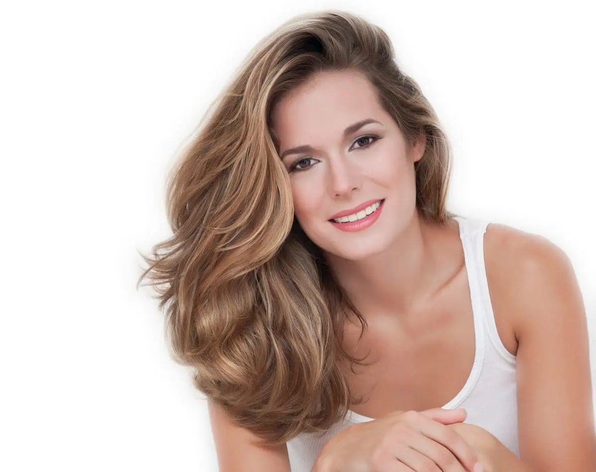 A woman with long, wavy light brown hair and a white tank top smiles at the camera against a plain white background—perfect for those looking to Improve Your Photography with simple, clean portrait setups.