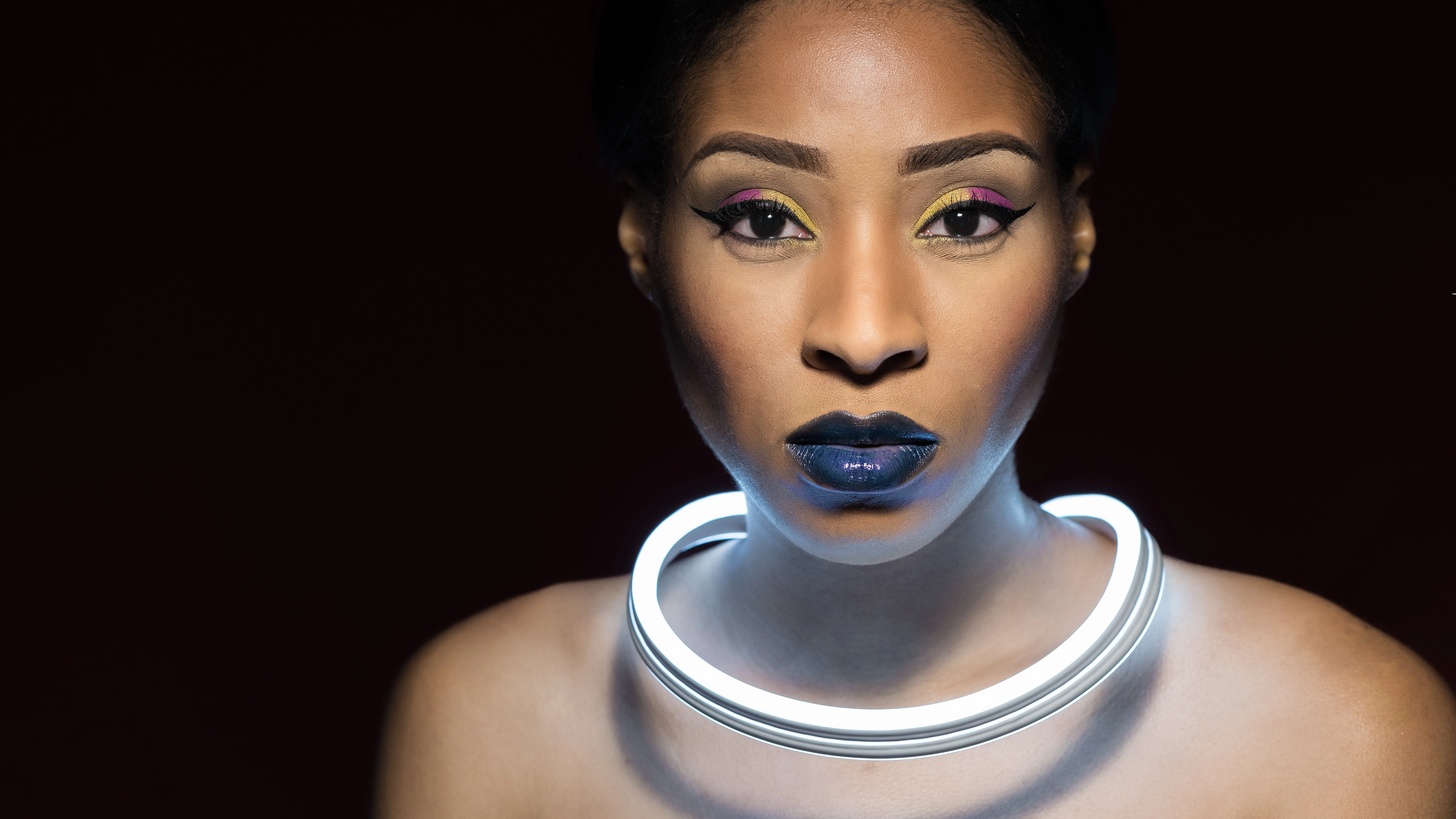 Monae with LED light around neck and black background, no Christmas lights