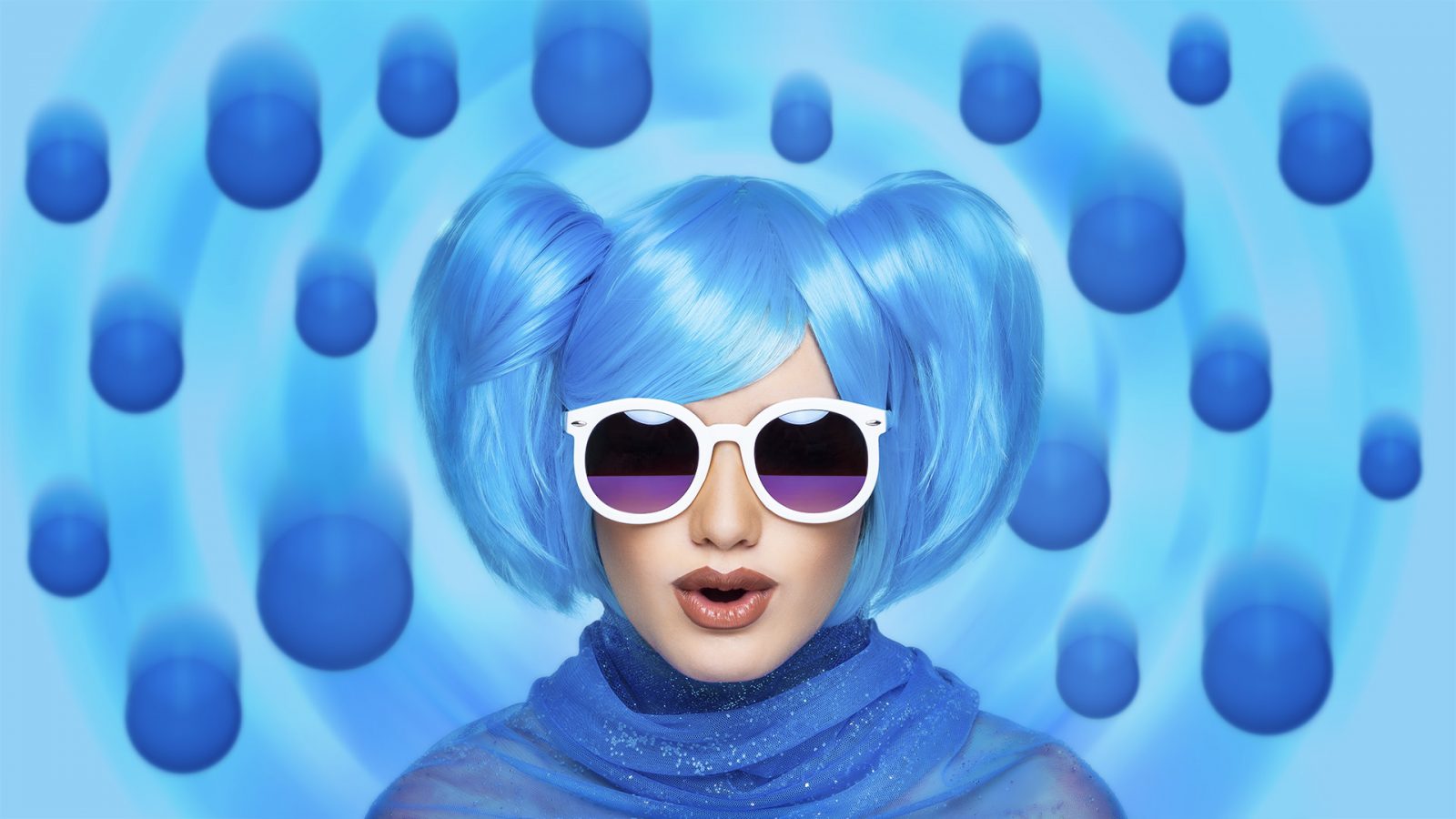 Fashion portrait with white sunglasses, blue hair and floating balls.