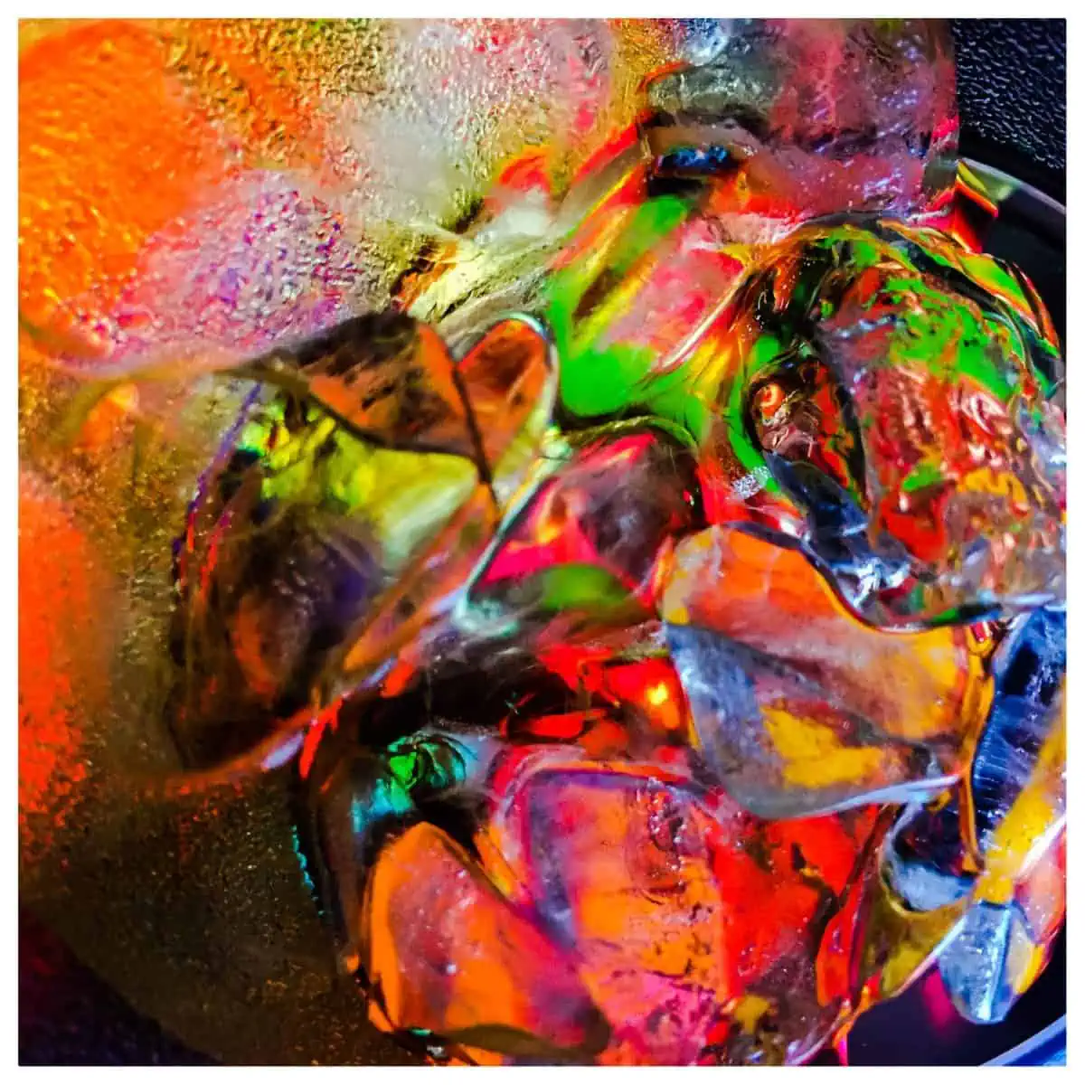 A close up of colorful ice cubes in a bowl.