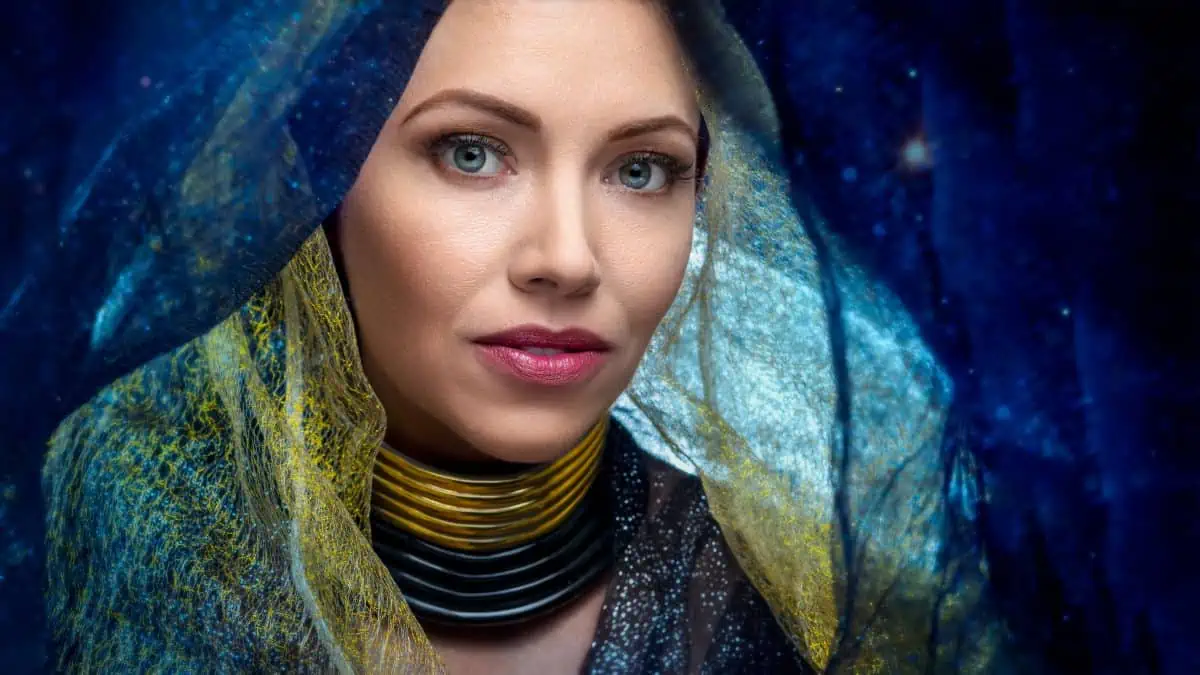 A woman wearing a veil in front of a starry sky.