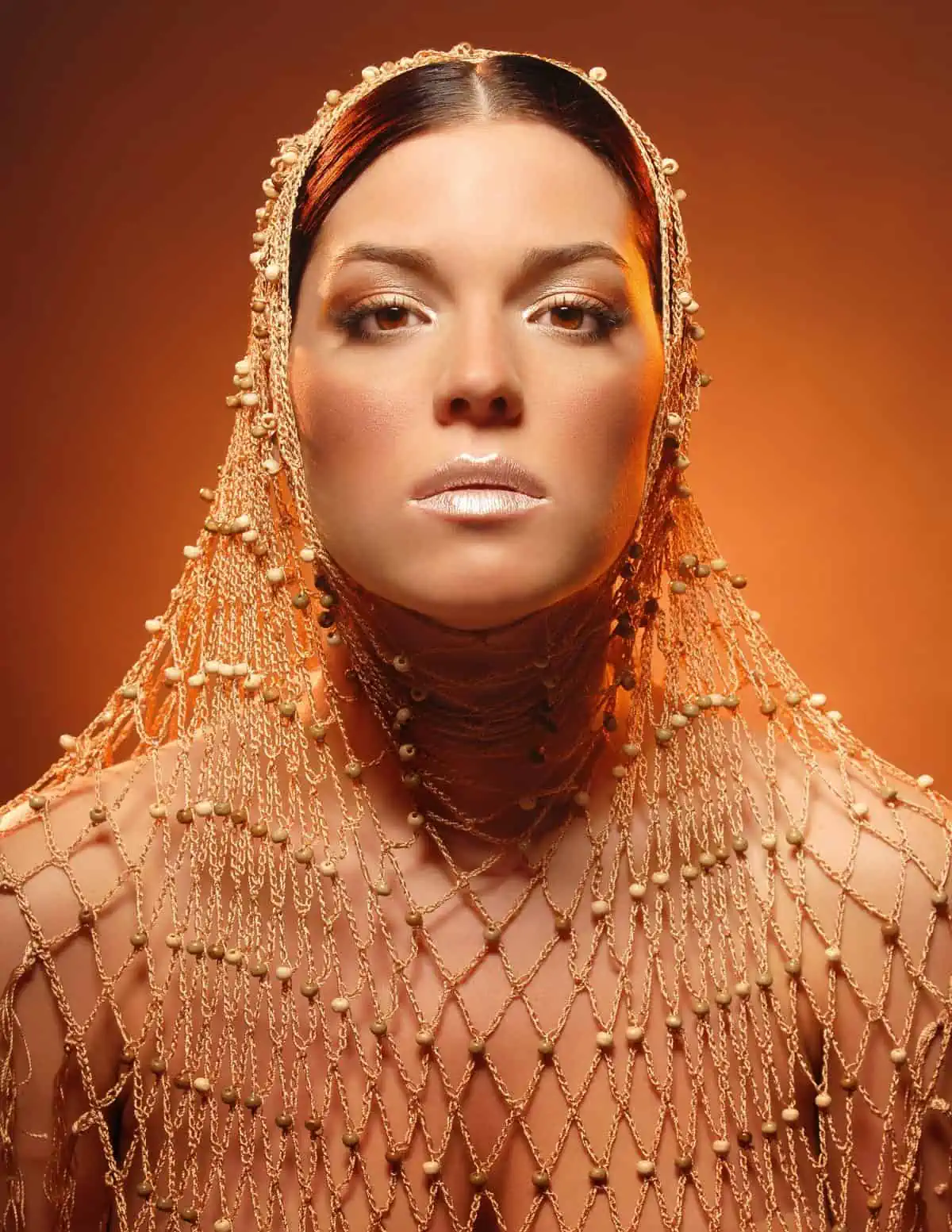 A woman in a gold dress posing for a photo.