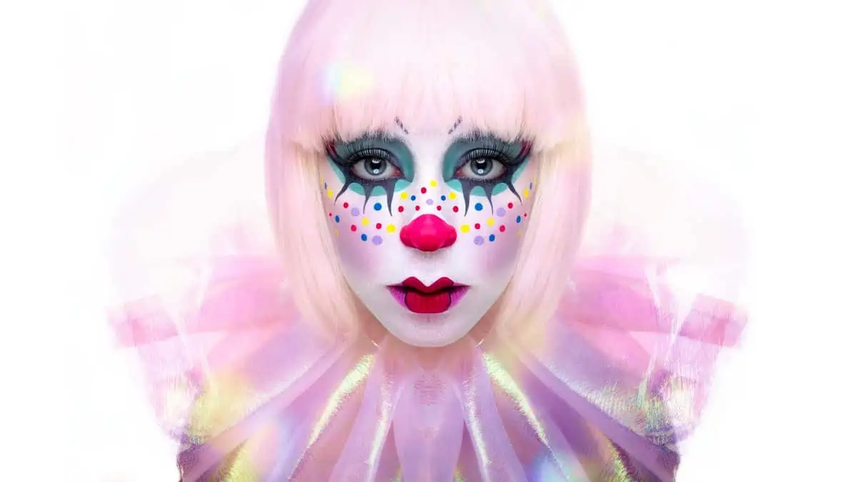 A woman with pink makeup and polka dots on her face.