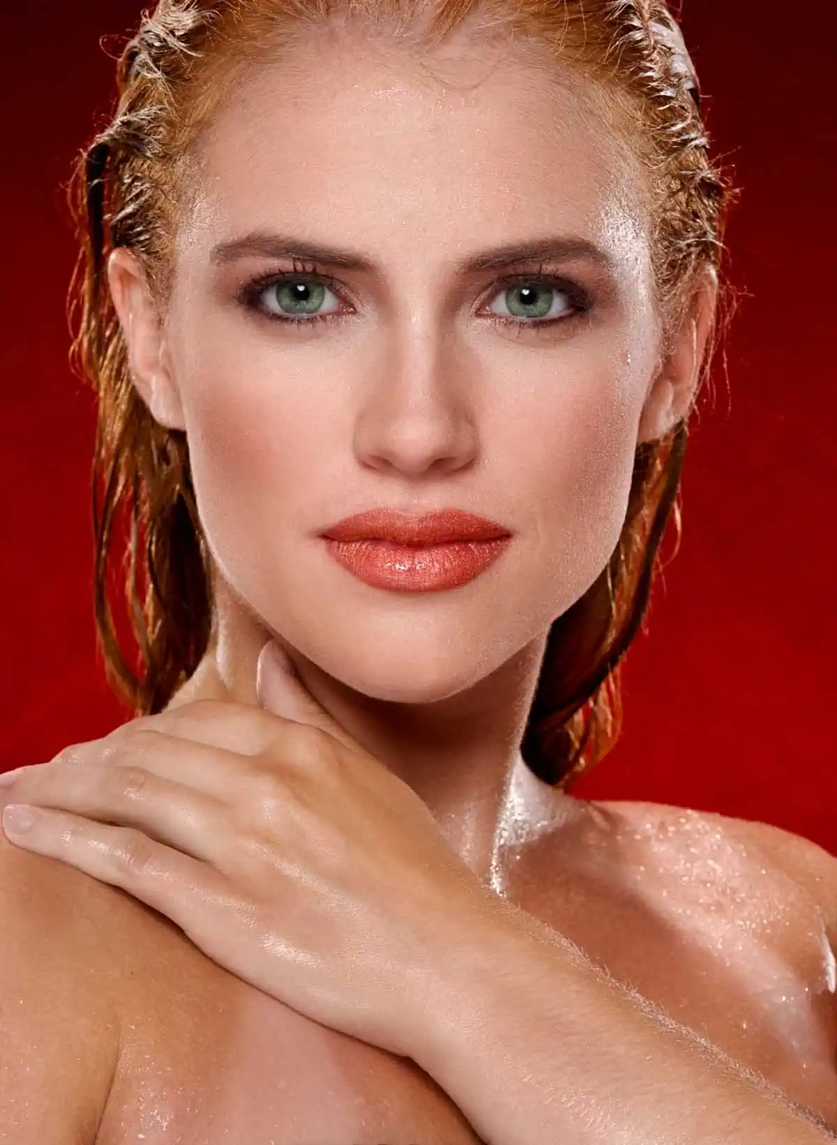 A woman with red hair and green eyes posing for a photo.