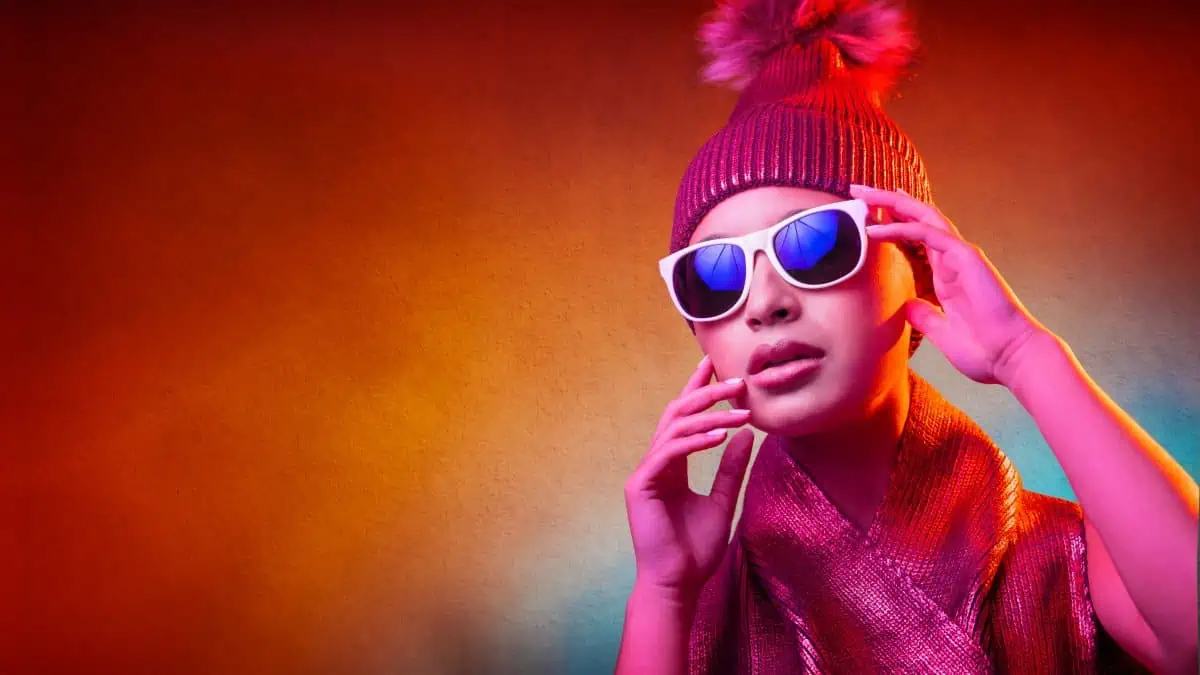 A woman wearing sunglasses and a beanie.