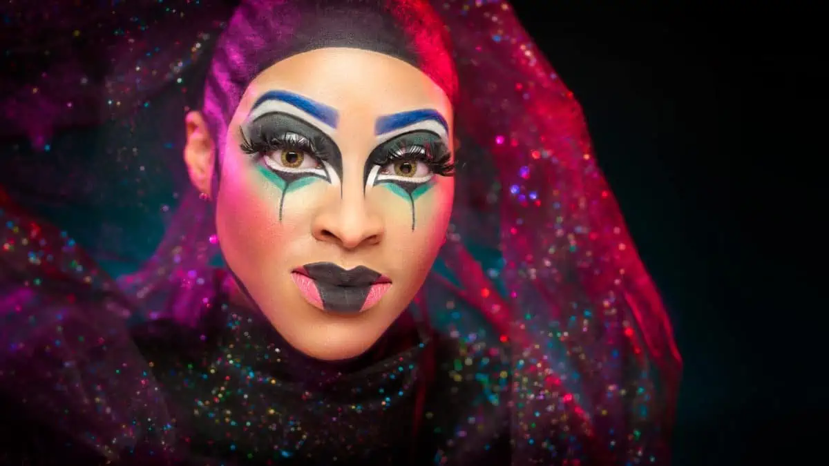 A woman with colorful makeup and makeup on her face.