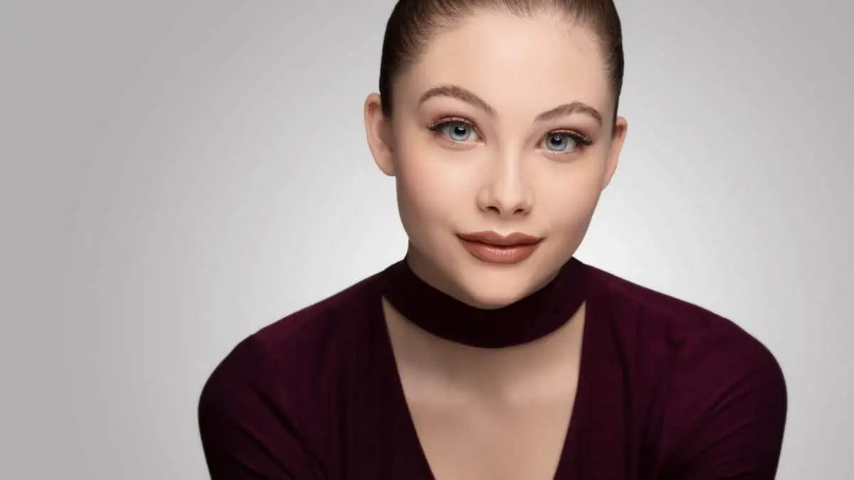 A woman in a burgundy top posing for a photo.