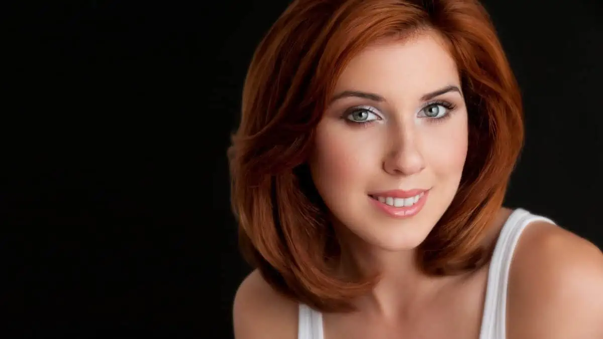 A woman with red hair is posing for a photo.