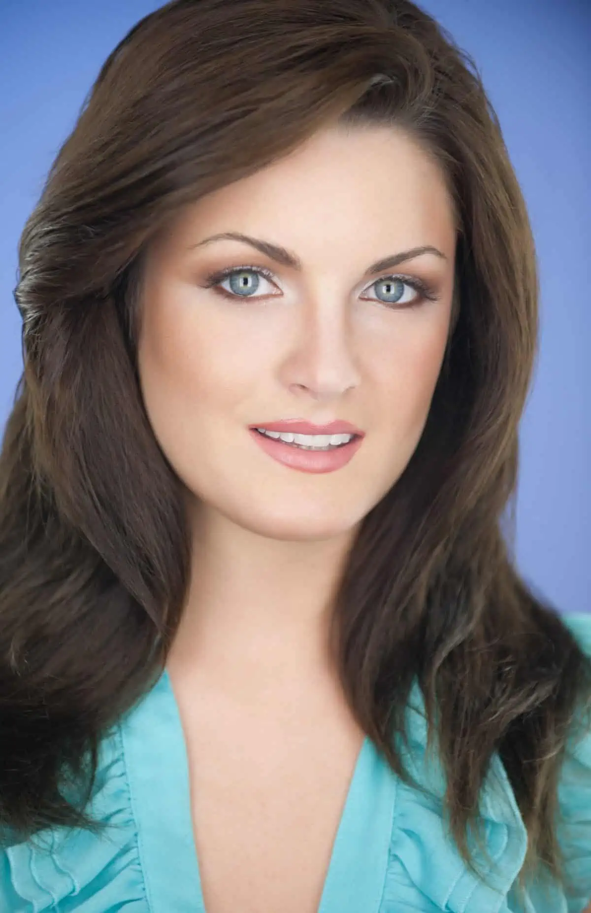 A woman with long brown hair posing for a photo.