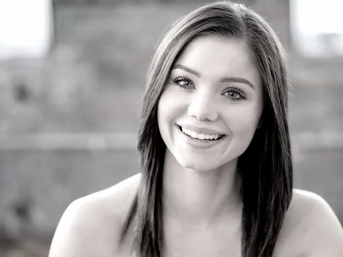 A black and white photo of a woman smiling.