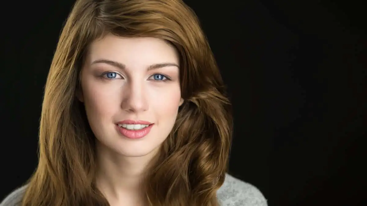 A woman with long brown hair is posing for a photo.