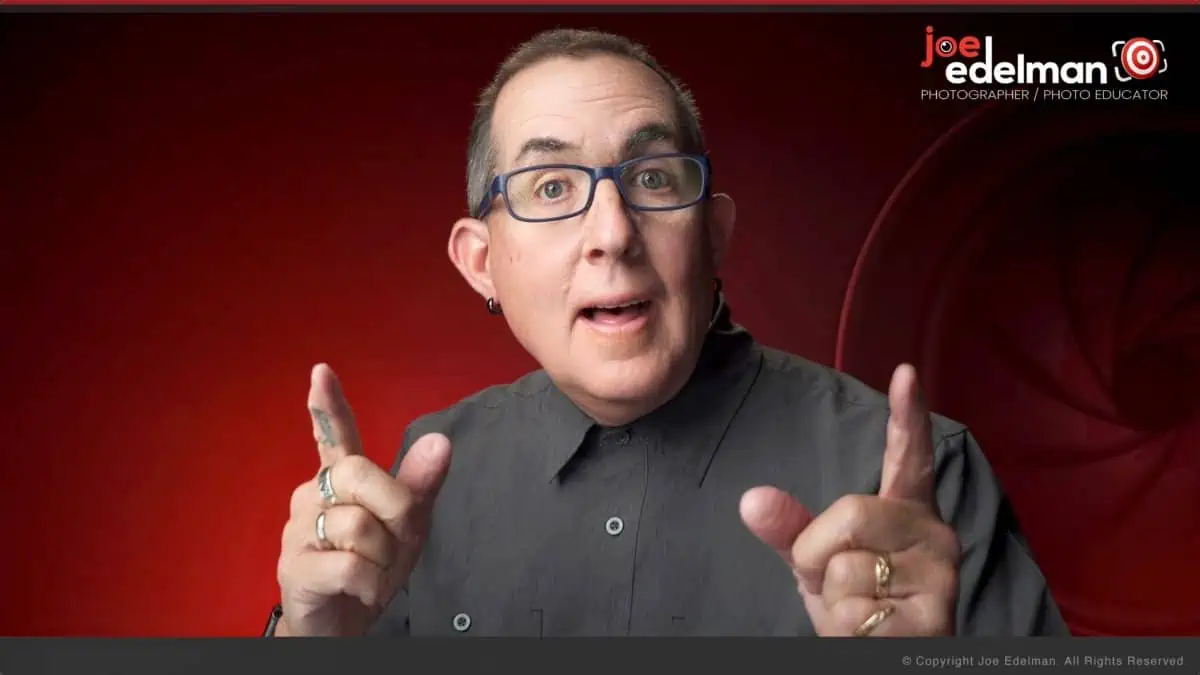 A man with glasses is making a gesture with his fingers.