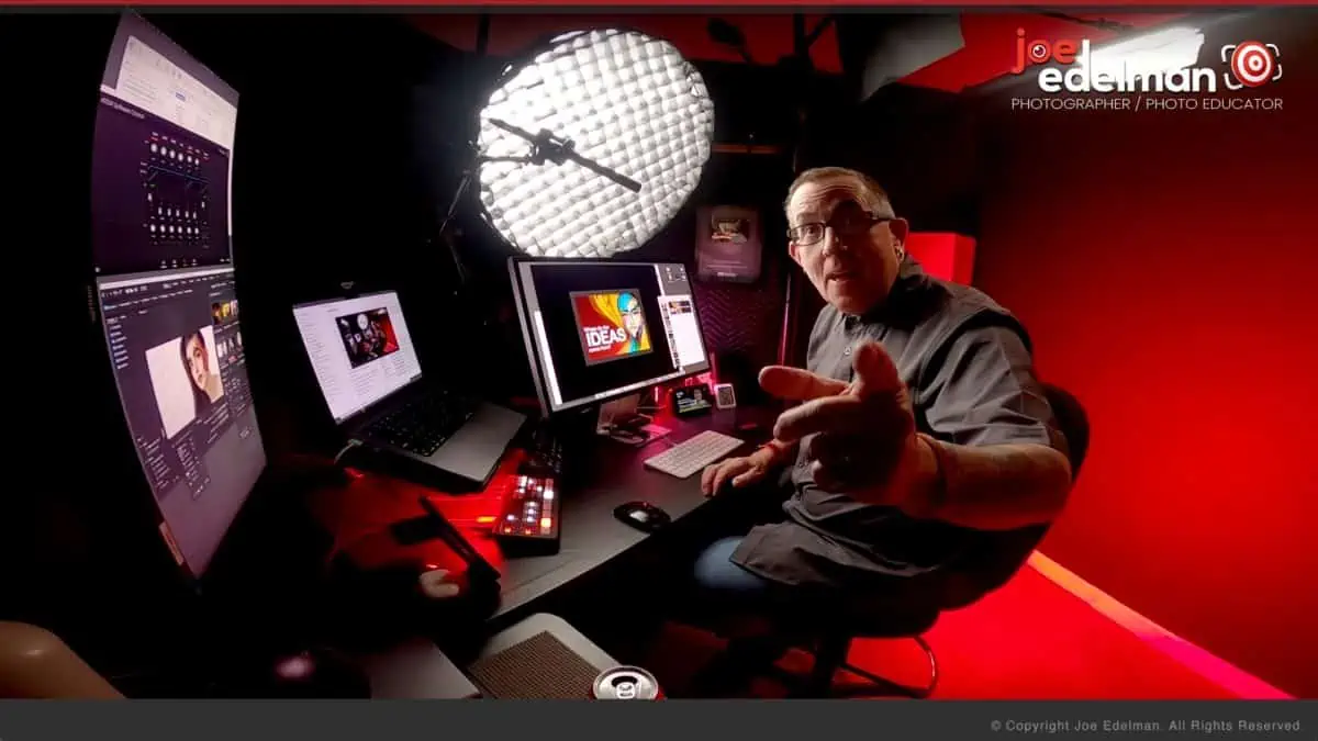 A man is sitting at a desk in front of a monitor.