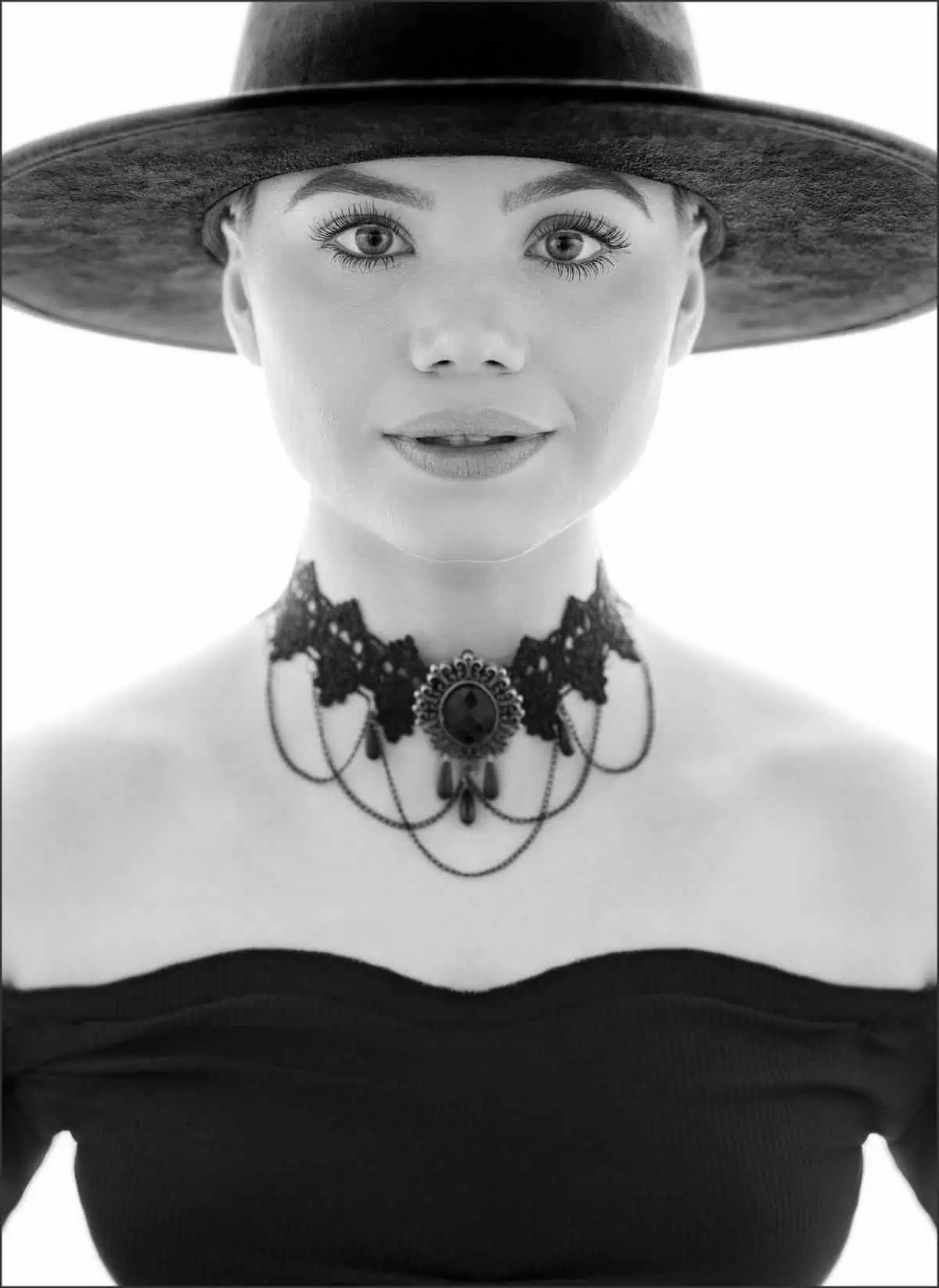 A backlit beauty photo of a woman wearing a hat.