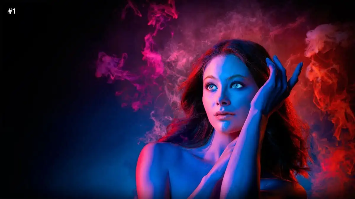 An image of a woman with blue smoke on her face.