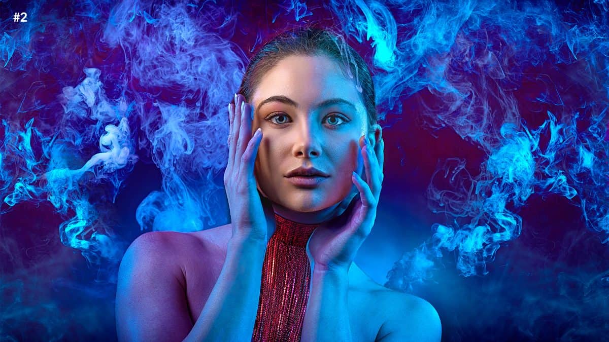 A woman with blue smoke in front of her face.