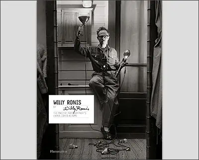 A black and white photo of Willy Ronis standing in a doorway.