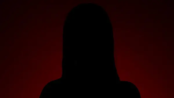 A creative silhouette portrait of a beautiful woman on a vibrant red background.