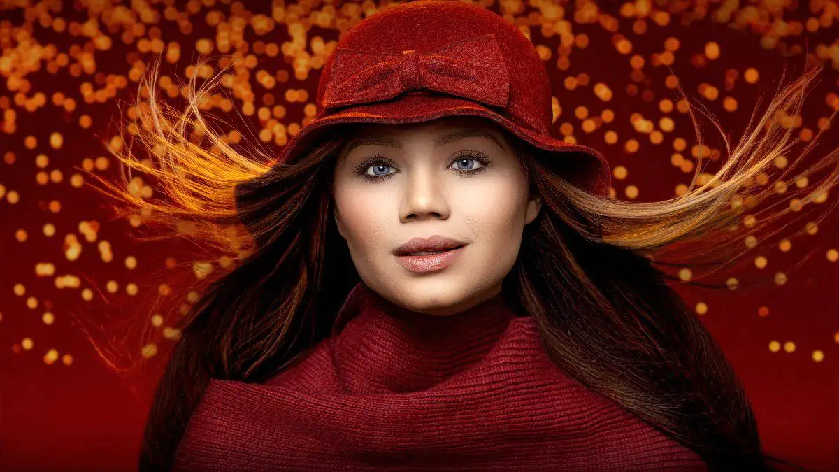 A woman in a red hat is posing creatively in front of lights, showcasing her beauty.
