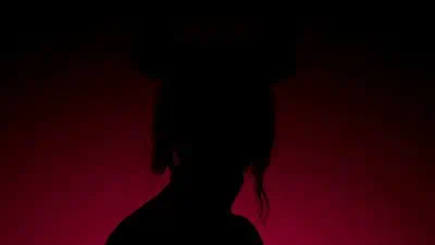 A colorful silhouette of a person with hair in the dark