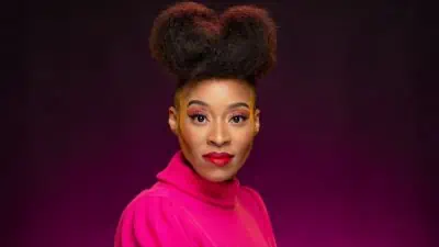 A colorful woman with a pink sweater in a beauty portrait.