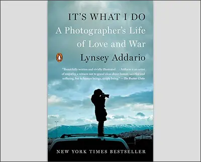 A book cover titled "It's What I Do: A Photographer's Life of Love and War," by Lindsay Adler, featuring a silhouette of a photographer holding a camera against a background of a sky with