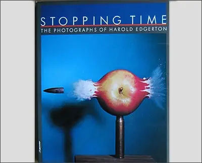 A poster advertising "stopping time," an exhibit showcasing the high-speed photography of Harold Edgerton, depicting an apple being pierced by a bullet, inspired by Alfred Eisenstaedt.