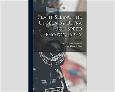 A camera positioned next to a book titled "Flash! Seeing the Unseen by Ultra High-Speed Photography" by Harold Eugene Edgerton, James Rhyne Killian, and Alfred Eisenstaed