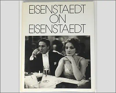 A book cover titled "eisenstaedt on eisenstaedt," featuring a black-and-white photograph by Dorothea Lange of a man and woman at a social event.