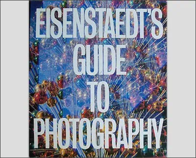 A book cover titled "Dorothea Lange's Guide to Photography" with a background of colorful light patterns.
