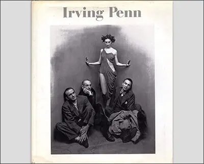 Fashion model standing poised above three seated men in an Irving Penn photograph.