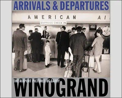A vintage photo of people at an airport check-in counter with a sign reading "arrivals & departures american ai," titled "the airport pictures of garry winogrand.