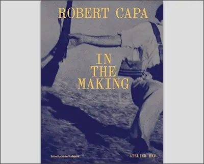 Cover of "Robert Capa: In the Making," featuring a blurred action photo of a person running, edited by Michael Lebeau. This tribute to the legendary war photographer is adorned with striking blue and yellow text.