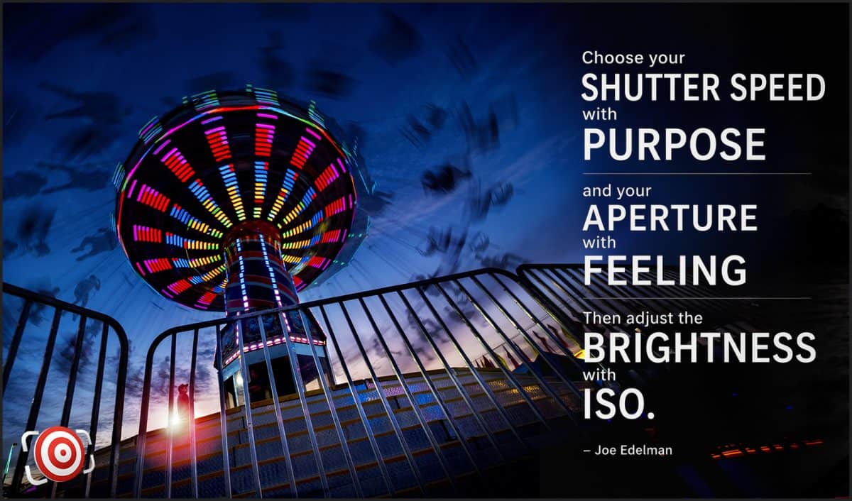 A spinning, brightly lit carnival ride at night is photographed with motion blur, showcasing the impact of manual exposure settings; a quote about photography by Joe Edelman is displayed on the right side of the image.