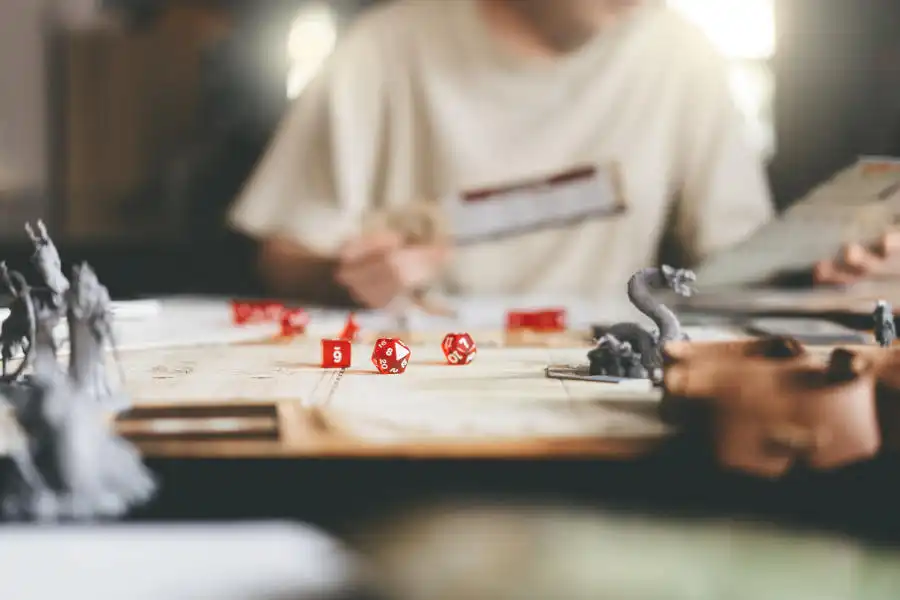 Ein Spielleiter sitzt am Tisch mit Rollenspiel Zubehör und Notizen zu Pen and Paper NPCs.