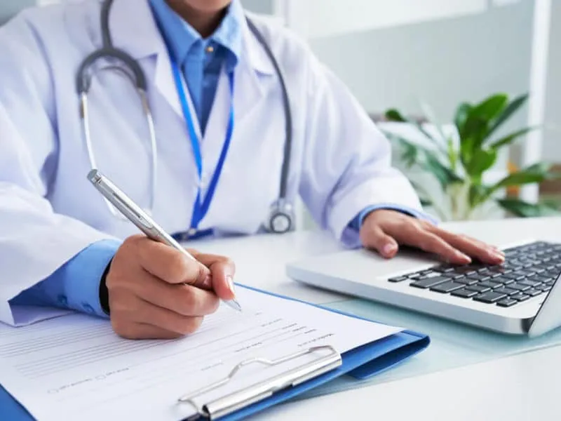Doctor-checking-information-in-computer-program-before-filling-medical-card-TeleLeaf-1