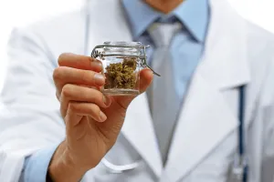 Doctor holding bottle with medical cannabis-TeleLeaf