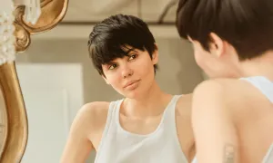 Young woman looking in the mirror smiling-TeleLeaf