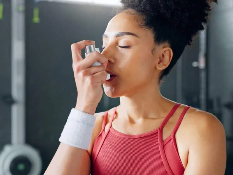 woman with asthma inhaler in gym