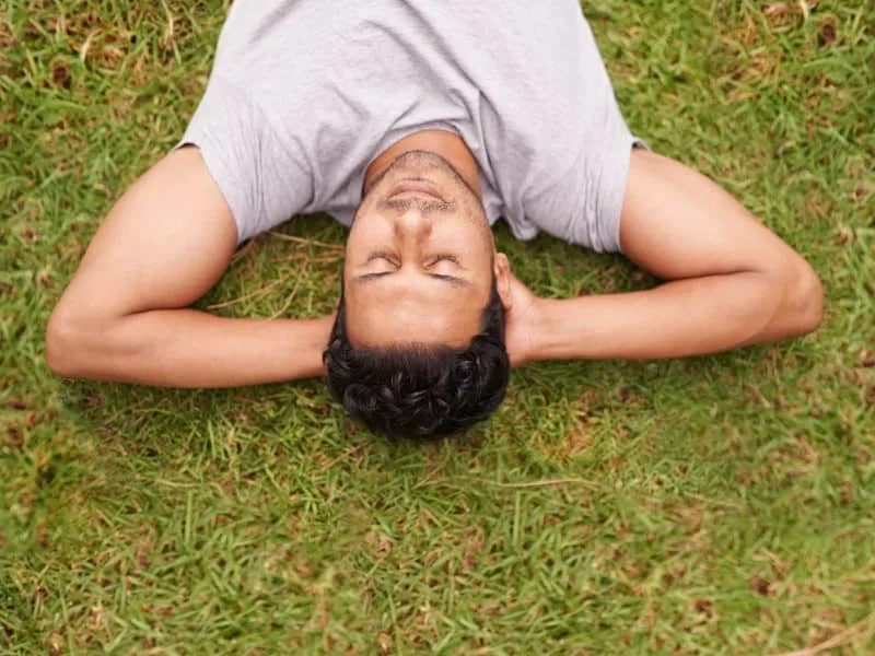 man laying on grass relaxing
