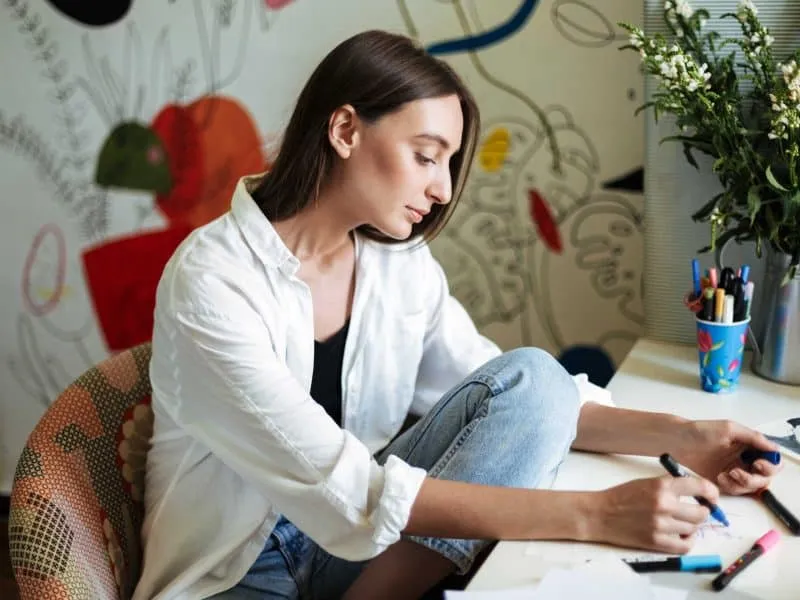 young girl sitting at desk drawing