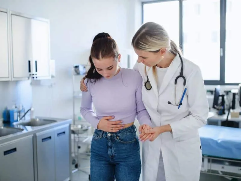 Close-up of doctor helping sick teenage girl in the ambulance office.
