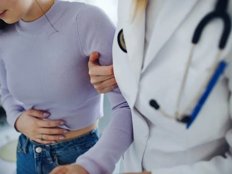 Close-up of doctor helping sick teenage girl in the ambulance office.