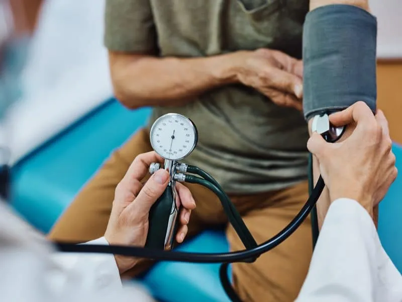 Close up of senior man getting his blood pressure checked during medical examination in the hospital.