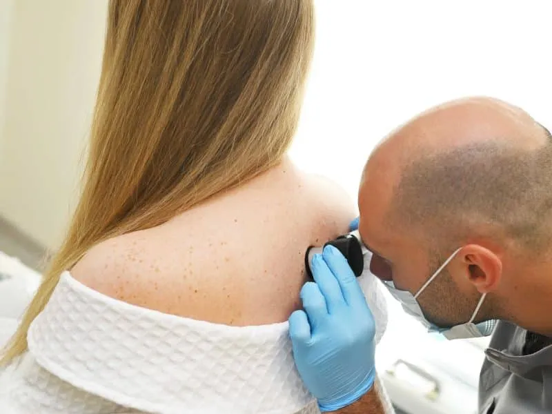 dermatologist examines patient skin