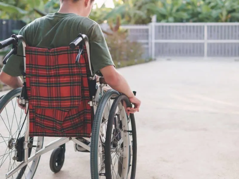 Young man with disability training move wheelchair by himself in the ramp of home or hospital,school,nursery, Self-help development in daily life, Positive photography and Good health concept.