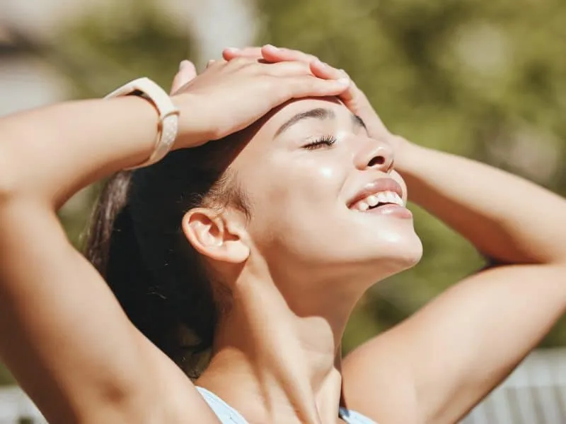 Nature, relax and woman in sun happy with outdoor leisure and peaceful break for mental wellness. S.