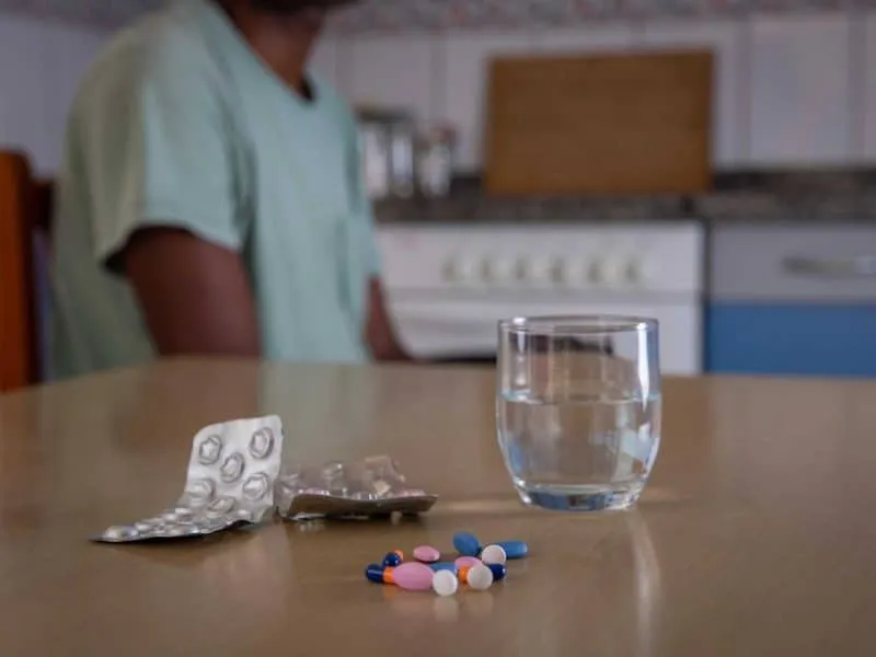 close up of medicine and a glass of water